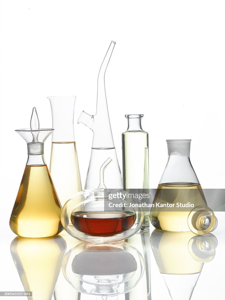 Decanter filled with different oil against white background