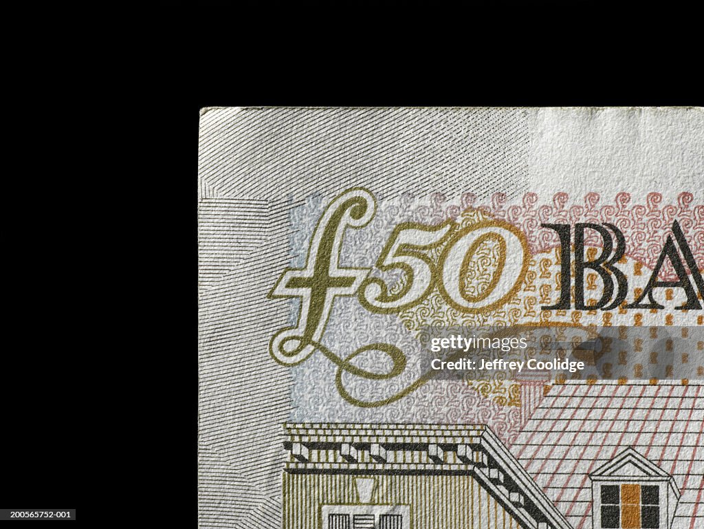 Fifty pound note against black background, close-up