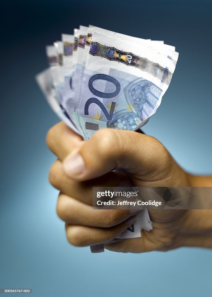 Human hand holding Euro currency in hand, close-up