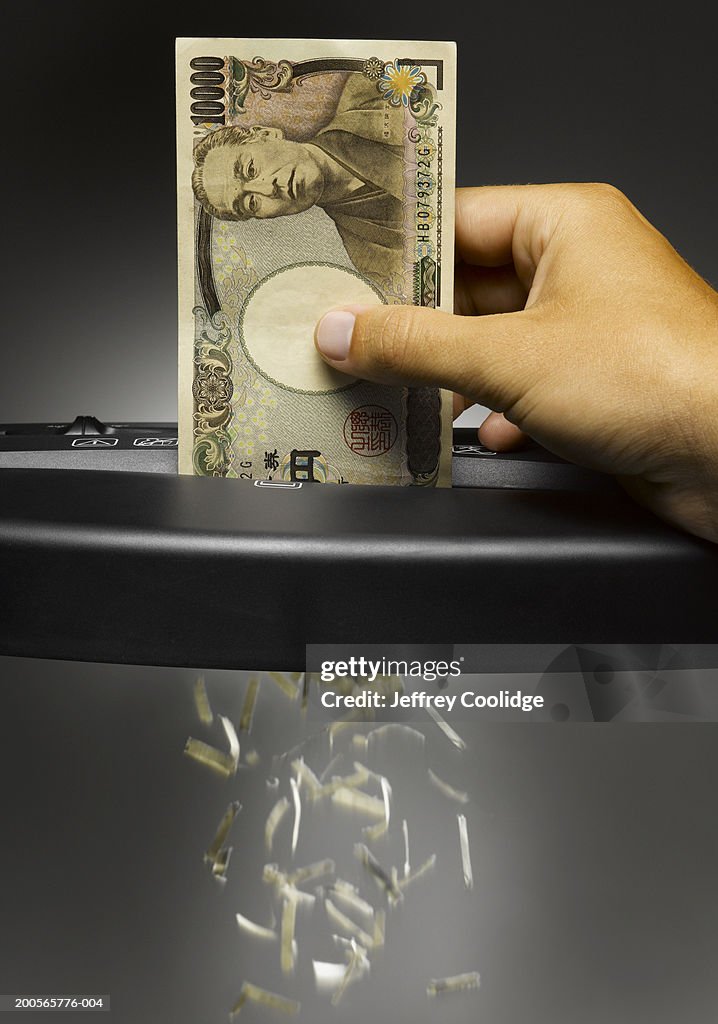 Man shredding ten thousand Yen banknote