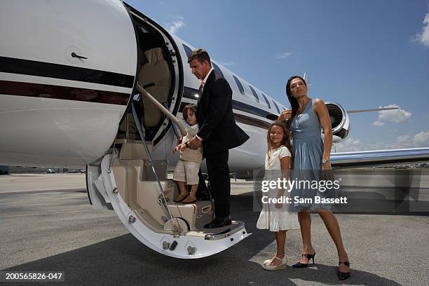 family boarding plane on runway - portrait of young woman standing against steps stock pictures, royalty-free photos & images