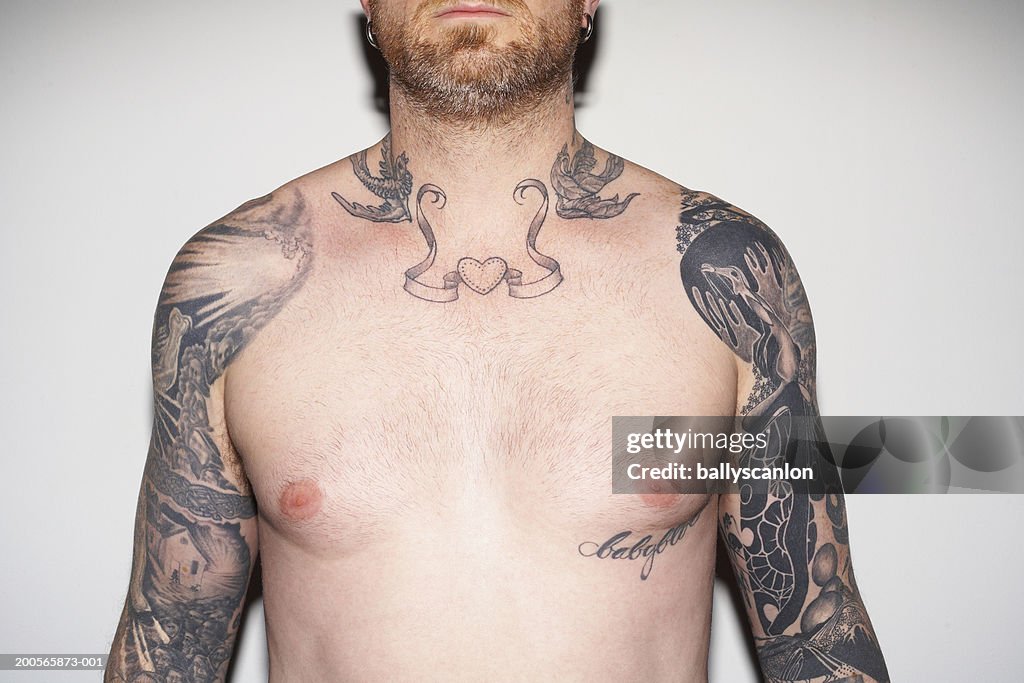 Bearded man with tattooed arms and neck, against white background
