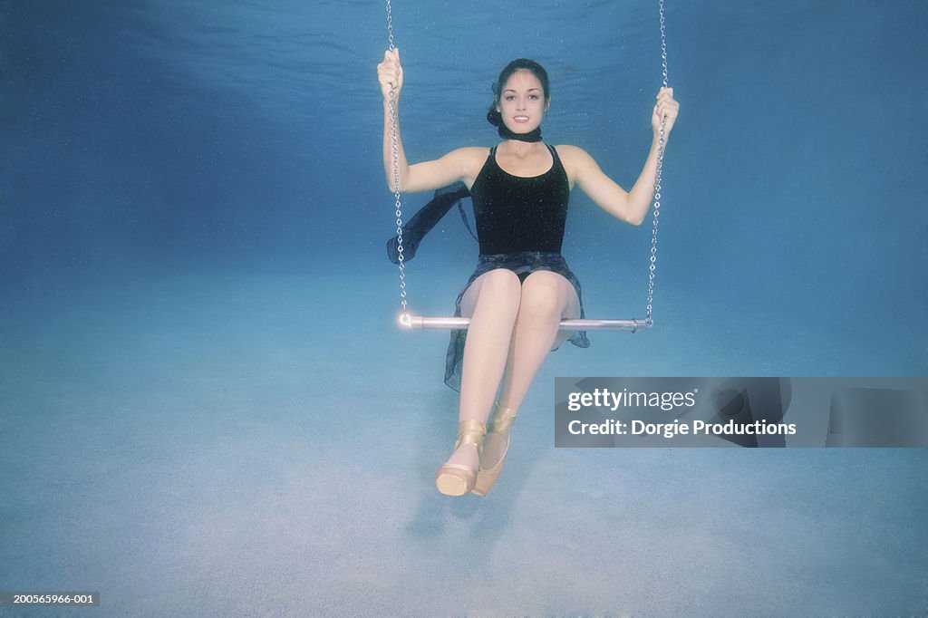 Young woman on swing underwater, portrait
