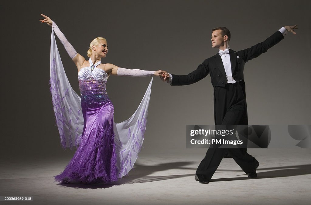 Ballroom dancing couple standing with outstretched arms