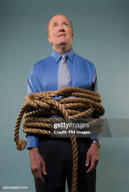 mature businessman tied up with rope - mann gefesselt stock-fotos und bilder