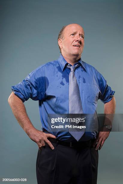 business man standing with hands on hips, shirt wet from sweating - sweat stock-fotos und bilder