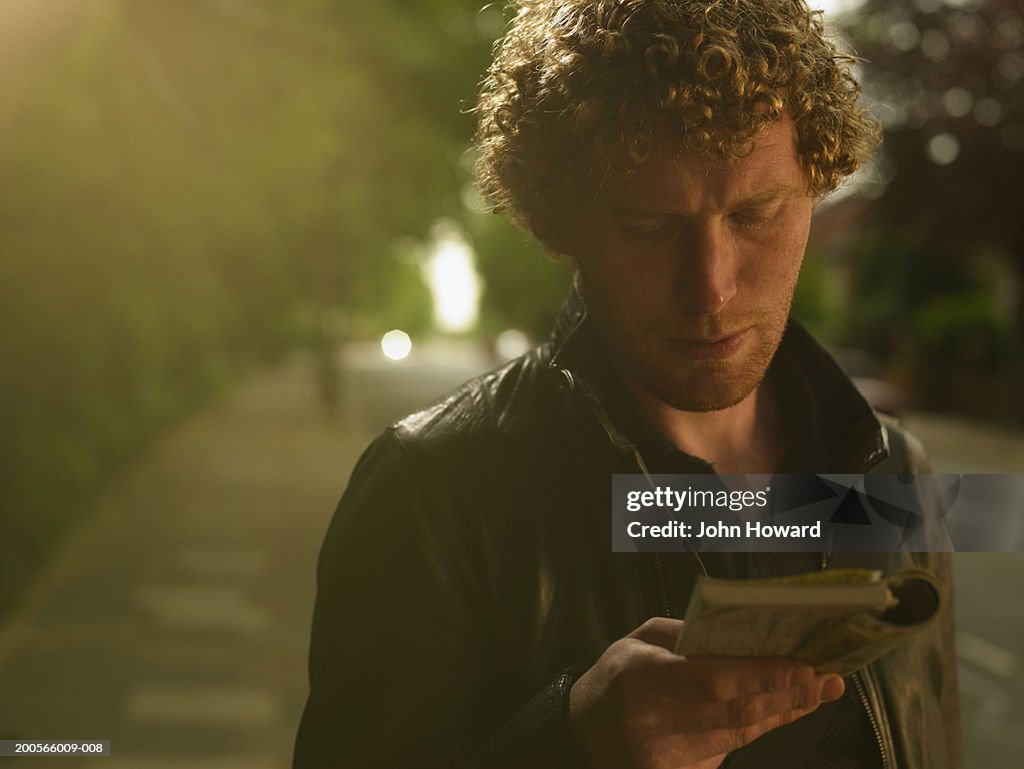 Man standing outdoors, looking at map