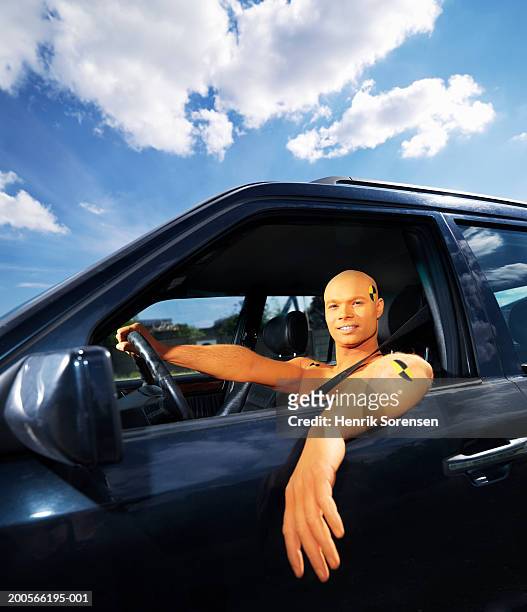 man dressed as crash test dummy sitting in car, portrait - crash test dummies stock-fotos und bilder