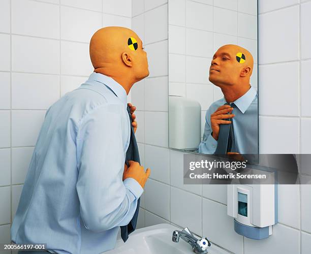 office worker dressed as crash test dummy adjusting tie in bathroom - crash test dummy stockfoto's en -beelden