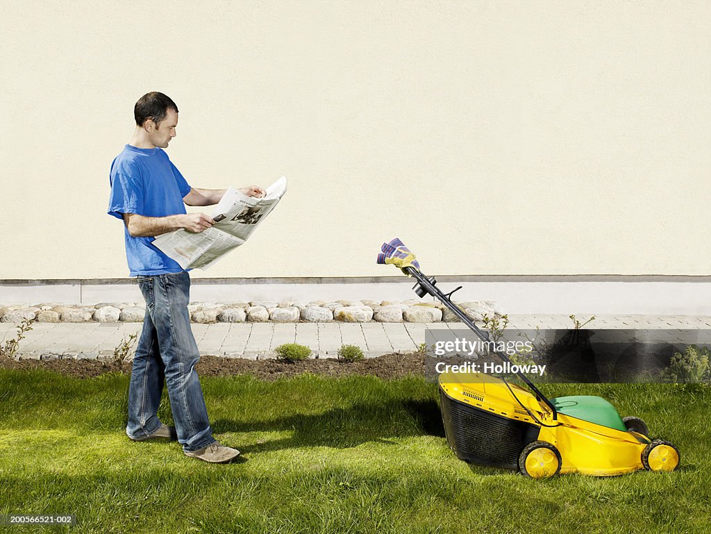 Man reading newspaper in garden, invisible person mowing grass with landmower (digital composite)