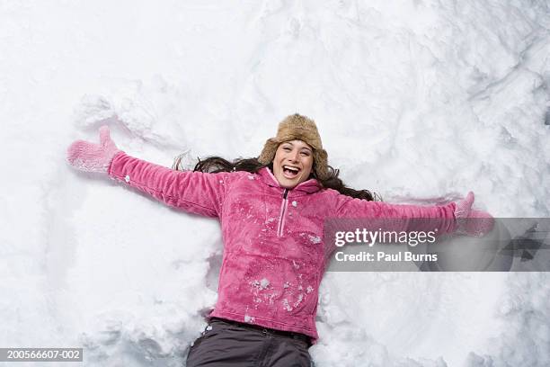 woman making snow angel smiling, portrait - snow angel stock pictures, royalty-free photos & images