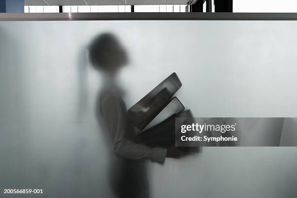 business woman carrying files behind screen in office - dossier secret stock-fotos und bilder