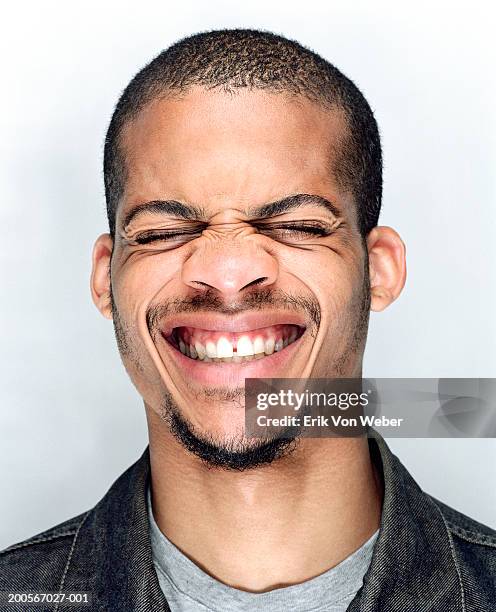 young man pulling a funny face, close-up - toothy smile 個照片及圖片檔