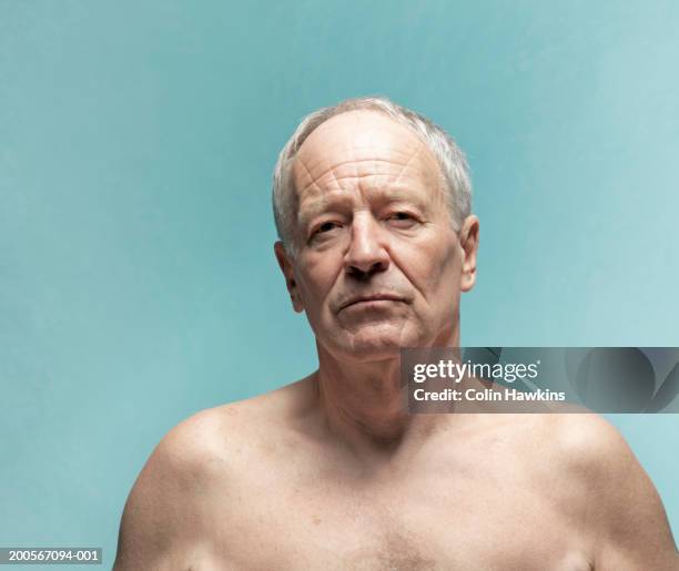 naked senior man against blue background, portrait - sin camisa fotografías e imágenes de stock