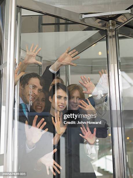 businesspeople stuck in revolving door - revolve fotografías e imágenes de stock