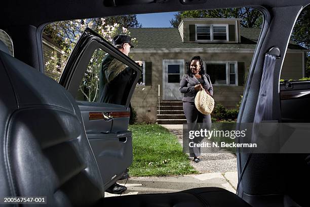 businesswoman being picked up by chauffer - limo stockfoto's en -beelden