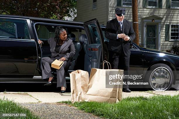 businesswoman getting out of car unassisted by chauffer - disembarking stock pictures, royalty-free photos & images