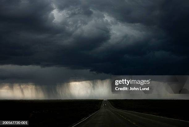 car with headlights on highway - storm fotografías e imágenes de stock