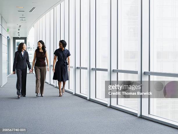 businesswomen walking in hallway, smiling, portrait - regierung stock-fotos und bilder
