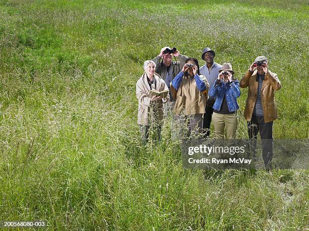 group of senior men and women in forest, using binoculars - bird watching stock pictures, royalty-free photos & images