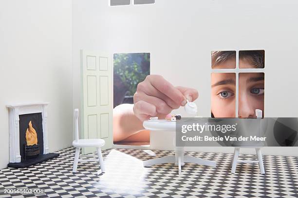 girl (10-11) peeking through window of dolls house, close-up - teapot stock pictures, royalty-free photos & images