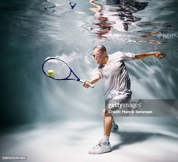 young man underwater playing tennis - man underwater stock pictures, royalty-free photos & images