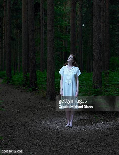young woman standing in forest, looking up - nightdress stock pictures, royalty-free photos & images