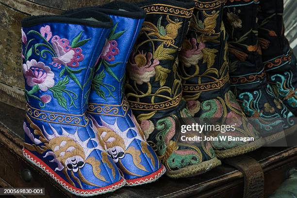 tiny boots for bound feet on market hawker stall - chinese foot binding stock pictures, royalty-free photos & images