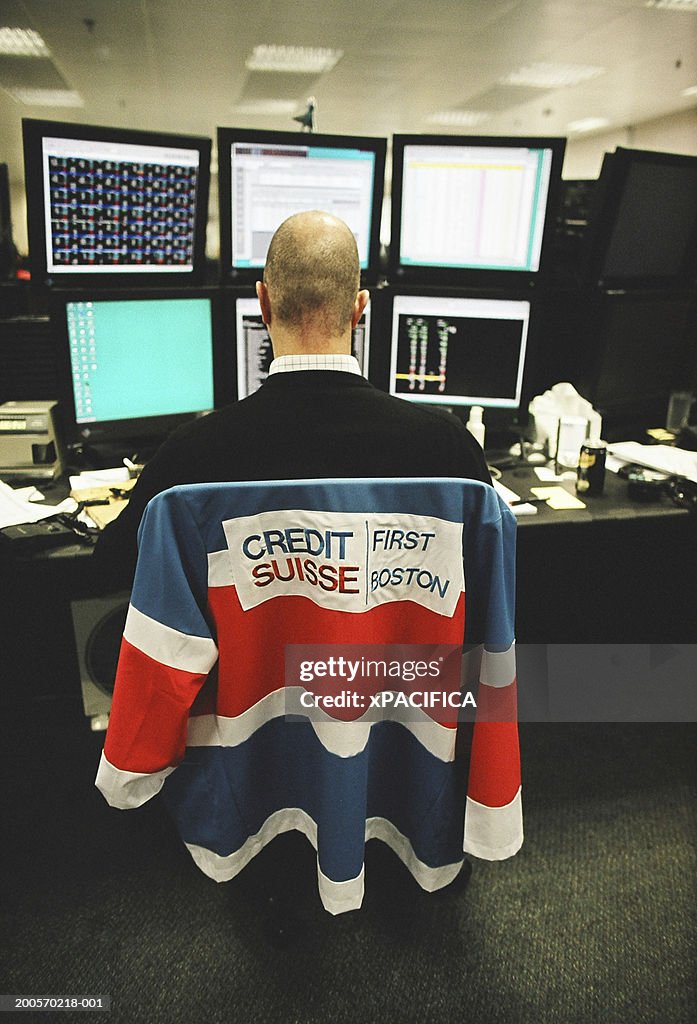 Businessman working desk with six monitors, rear view