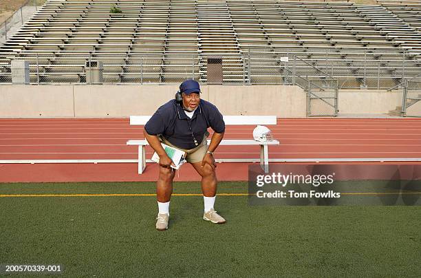 coach crouching on sidelines - side lines photos et images de collection