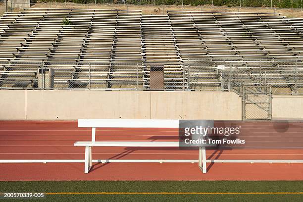 empty bench on sidelines of field - sideline stock-fotos und bilder