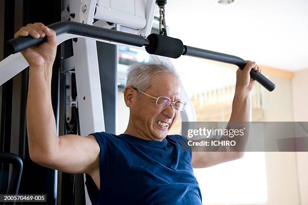 man pulling weight machine - trainingsmaschine stock-fotos und bilder