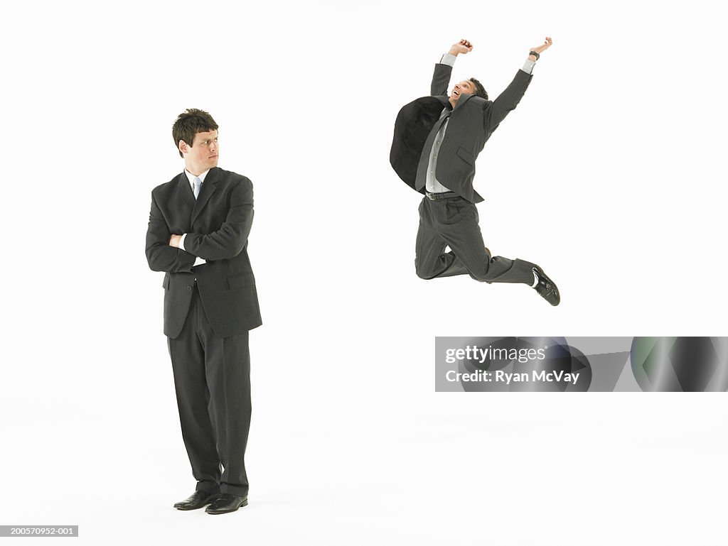Business man looking at colleague jumping