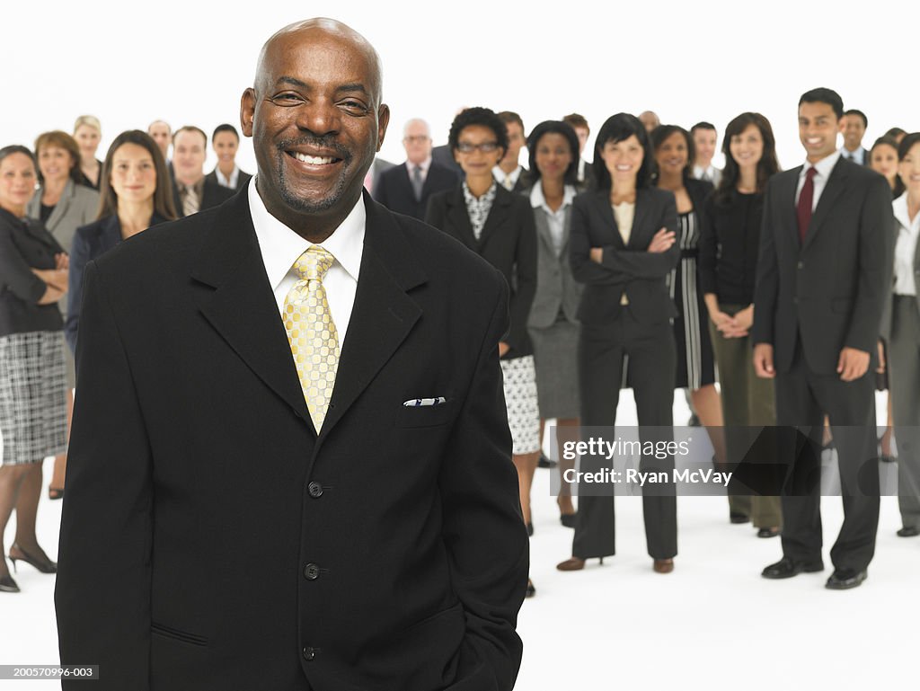 Business man standing in front of colleagues, focus on business man