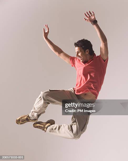 man jumping in air, smiling - camisa pólo imagens e fotografias de stock