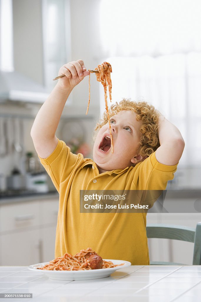 Boy (4-5) holding spaghetti, close-up, portrait