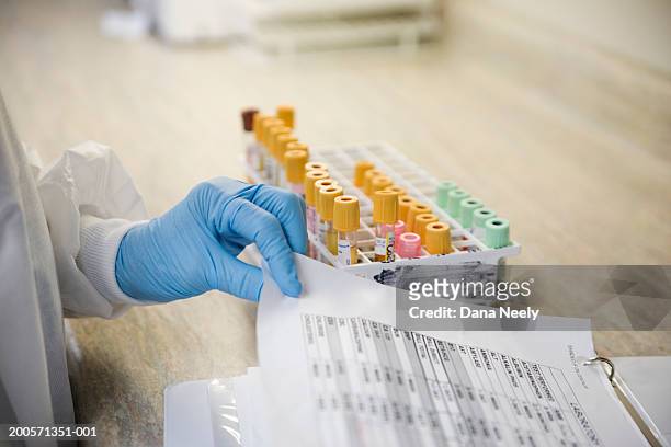 lab technician with blood samples and medical chart - blood tubes stock-fotos und bilder