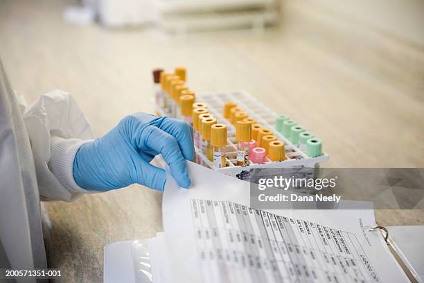 lab technician with blood samples and medical chart - provetta per campioni ematici foto e immagini stock