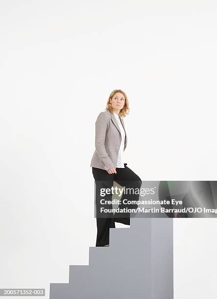 young businesswoman climbing stairs - looking around on white background stock pictures, royalty-free photos & images