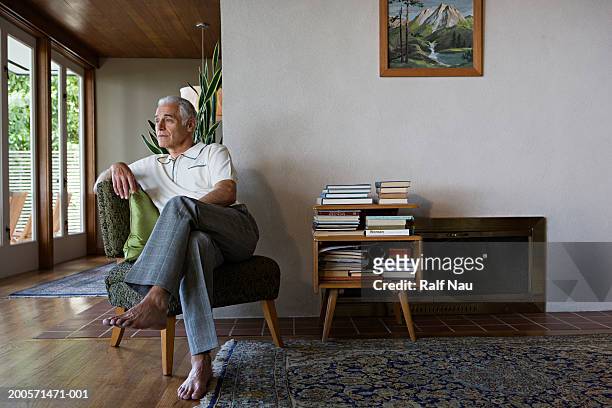 senior man sitting on chair, looking away - legs crossed at knee stock pictures, royalty-free photos & images