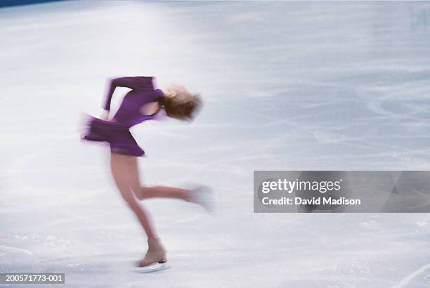 female ice skater spinning on ice - kunstschaatsen stockfoto's en -beelden