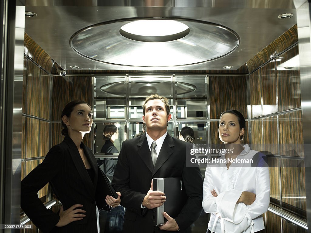 Three business colleagues standing in elevator