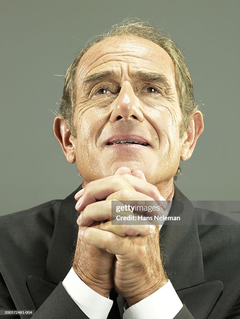 Senior business man with hands clasped, portrait