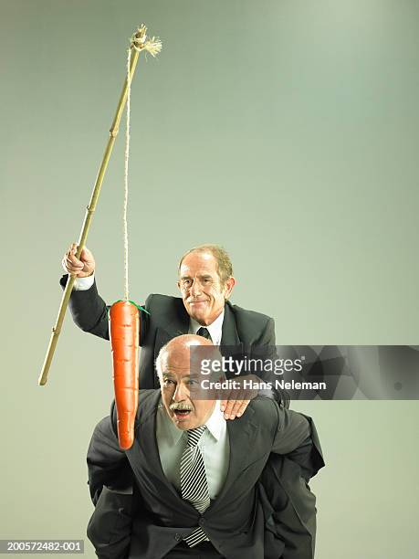 business man having piggy back, dangling carrot in front of colleague - suits hanging stock pictures, royalty-free photos & images