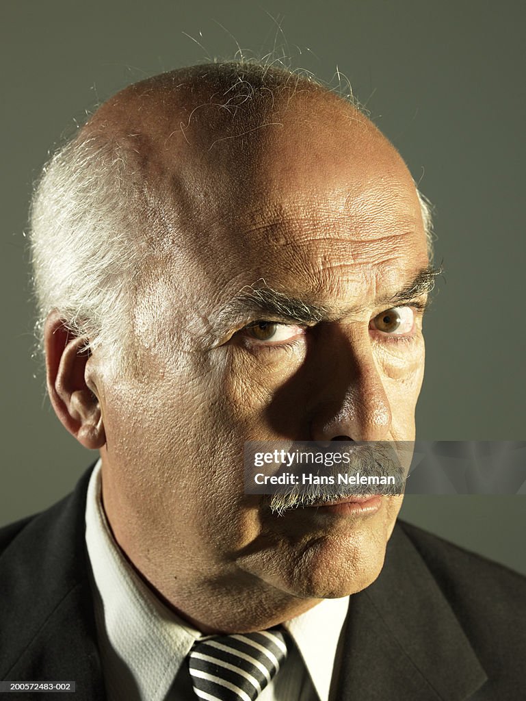 Stern senior business man, close-up, portrait