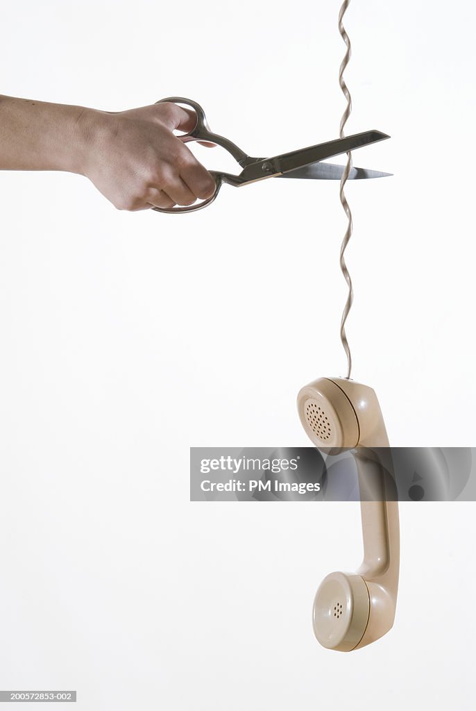 Woman cutting telephone cable, close-up