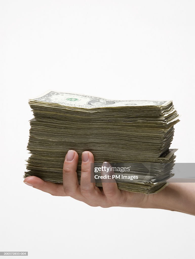 Woman holding stack of US dollar banknotes, close-up