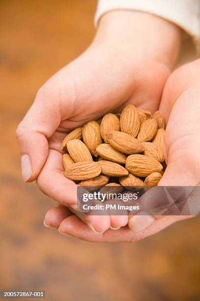 woman holding almonds, close-up - almond stock pictures, royalty-free photos & images