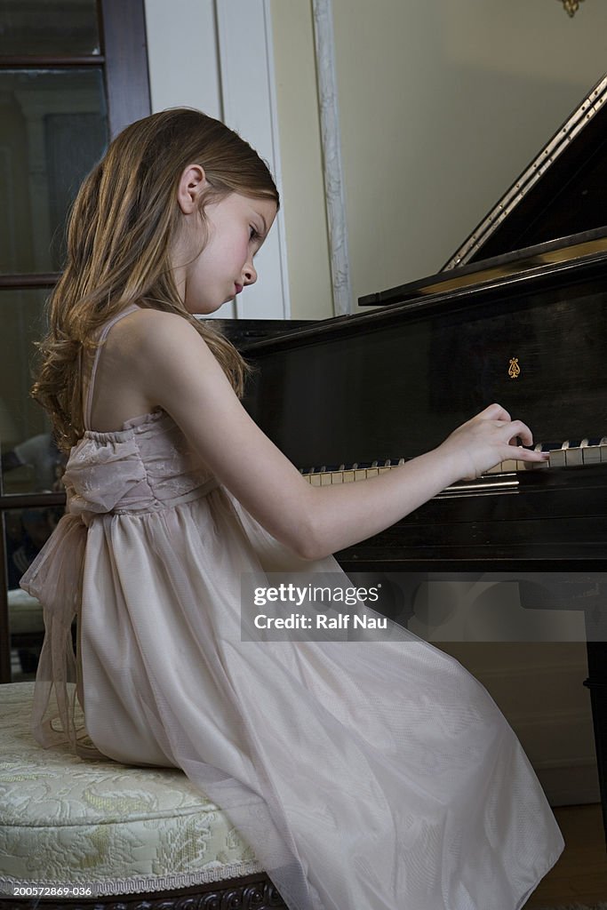 Girl (6-8) playing piano