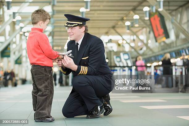 airline pilot showing young boy (4-5) model aeroplane - model aeroplane stock pictures, royalty-free photos & images